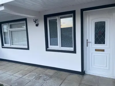 a white house with a white door and windows at Spacious 1-Bed Apartment - Sleeps 2 & Parking in Truro