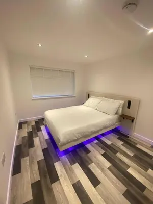 a bedroom with a bed with lights on the floor at Spacious 1-Bed Apartment - Sleeps 2 & Parking in Truro