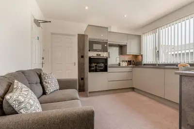 a living room with a couch and a kitchen at 1 Bed in Newquay oc-s32400 in Holywell Bay