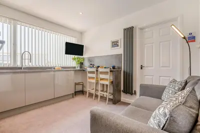 a living room with a couch and a kitchen at 1 Bed in Newquay oc-s32400 in Holywell Bay