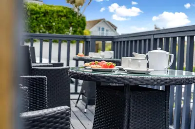 a table with a plate of food on a patio at 1 Bed in Newquay oc-s32400 in Holywell Bay