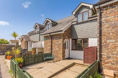 a brick house with a fence in front of it at 2 Bed in St. Issey oc-a32428 in Saint Issey