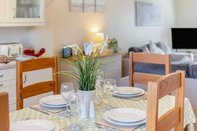 a dining room table with plates and glasses on it at 2 Bed in St. Issey oc-a32428 in Saint Issey