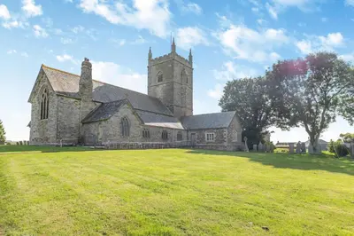 an old church with a grass field in front of it at 2 Bed in St. Issey oc-a32428 in Saint Issey