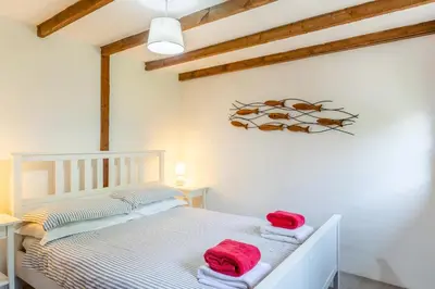 a bedroom with a white bed with red towels on it at 2 Bed in Fowey oc-d32427 in Fowey