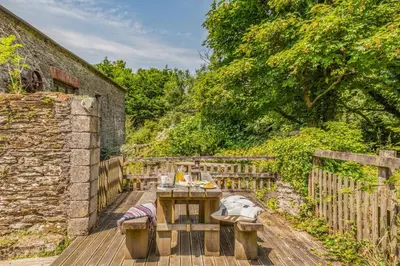 a wooden table and benches on a wooden deck at 2 Bed in Fowey oc-d32427 in Fowey
