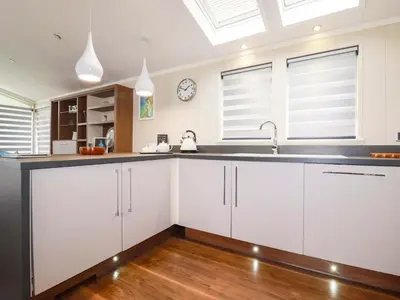 a kitchen with white cabinets and a sink at The Maples 44 in St Austell
