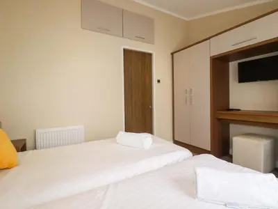 a bedroom with two beds and a tv on the wall at The Maples 44 in St Austell