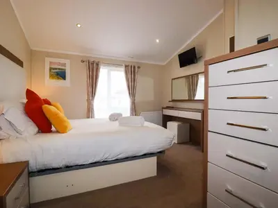 a bedroom with a white bed and a dresser at The Maples 44 in St Austell