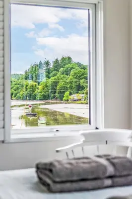 a window with a view of a body of water at Holiday Home Riverside Cottage by Interhome in Lerryn
