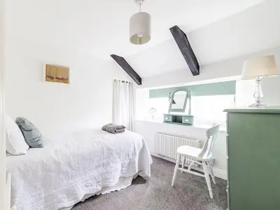 a bedroom with a bed and a desk and a chair at Holiday Home Riverside Cottage by Interhome in Lerryn