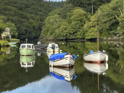 three boats are docked in a body of water at Holiday Home Riverside Cottage by Interhome in Lerryn
