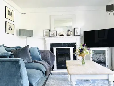 a living room with a blue couch and a fireplace at Holiday Home Riverside Cottage by Interhome in Lerryn