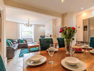 a dining room and living room with a wooden table at Holiday Home Tregony House by Interhome in Mevagissey