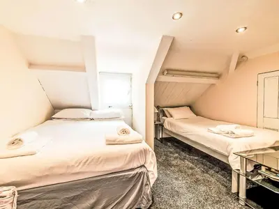 two beds in a small room with a window at Holiday Home Tregony House by Interhome in Mevagissey