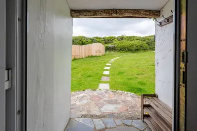 an open door with a view of a field of grass at Cleave Cottage in Crackington Haven