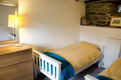 a small bedroom with a bed and a dresser at Cleave Cottage in Crackington Haven