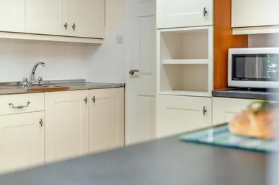 a white kitchen with a sink and a microwave at 2 Bed in Looe oc-g32529 in Looe