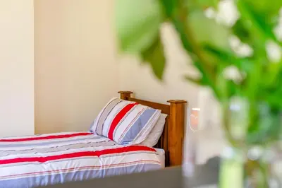 a bed with a red and white striped pillow on it at 2 Bed in Looe oc-g32529 in Looe