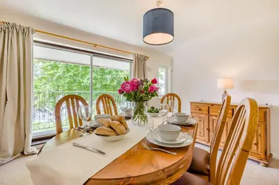 a dining room with a wooden table and a window at 2 Bed in Looe oc-g32529 in Looe