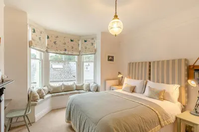 a bedroom with a bed and a window with a chair at 2 Bed in Fowey oc-p00638 in Fowey