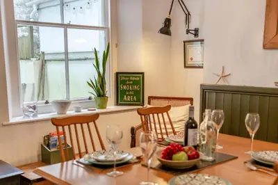 a dining room table with wine glasses and a bowl of fruit at 2 Bed in Fowey oc-p00638 in Fowey