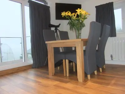 a dining room table with chairs and a vase of flowers at The Count House in Saint Hilary
