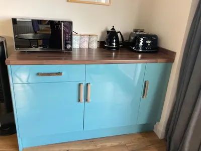 a blue cabinet with a microwave on top of it at The Count House in Saint Hilary