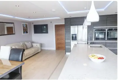 a living room with a couch and a bowl of fruit at Creek View House in Feock