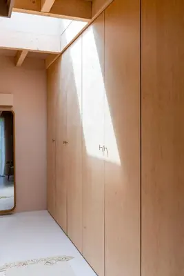 a room with a wall of wooden cabinets at The Architects Treehouse in Mount Hawke