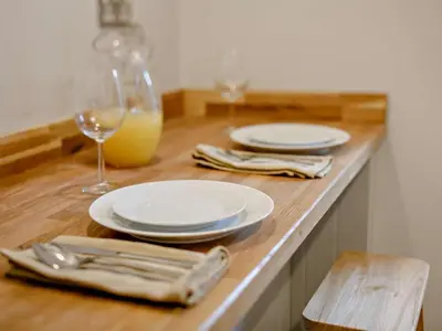 a wooden table with white plates and glasses of wine at 2 Bed in Fowey oc-91015 in Polruan
