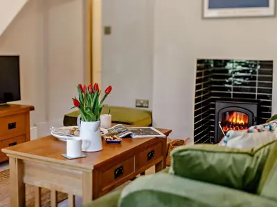 a living room with a coffee table and a fireplace at 2 Bed in Fowey oc-91015 in Polruan