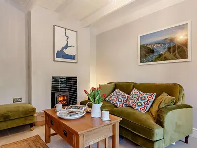 a living room with a green couch and a table at 2 Bed in Fowey oc-91015 in Polruan