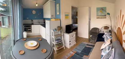 a kitchen and living room with a table in a room at 159 Atlantic Bays St Merryn in St Merryn