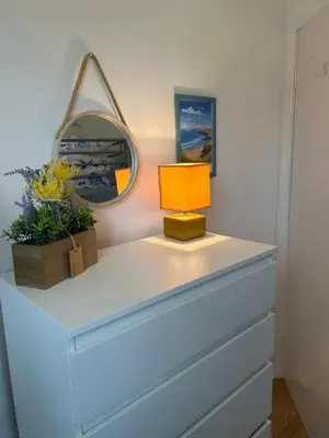 a dresser with a mirror and a lamp on it at 159 Atlantic Bays St Merryn in St Merryn