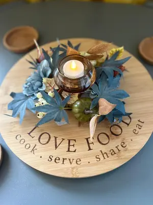 a wooden plate with a candle and flowers on it at 159 Atlantic Bays St Merryn in St Merryn