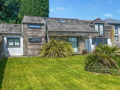 a house with a grass yard in front of it at The Saltings in Egloshayle