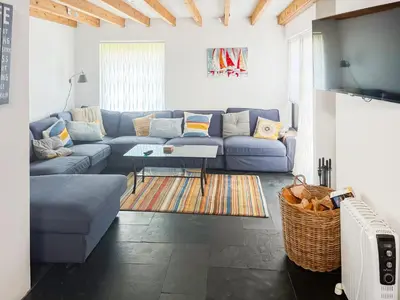 a living room with a blue couch and a table at The Saltings in Egloshayle