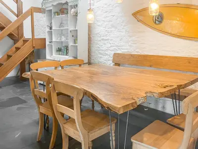 a wooden table and chairs in a room at The Saltings in Egloshayle
