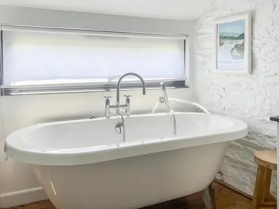 a white bath tub in a bathroom with a window at The Saltings in Egloshayle