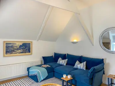 a living room with a blue couch at The Watch House in Saint Mawes
