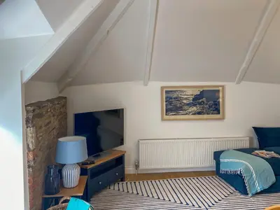 a bedroom with a bed and a flat screen tv at The Watch House in Saint Mawes