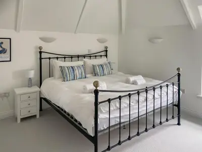a bedroom with a black bed with white sheets and pillows at The Watch House in Saint Mawes