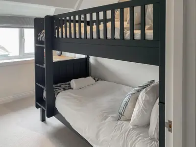 a black bunk bed in a room with a white mattress at The Watch House in Saint Mawes