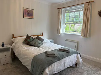 a bedroom with a bed and a window at La Mouette in Mevagissey
