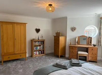 a bedroom with a bed and a desk and a mirror at La Mouette in Mevagissey