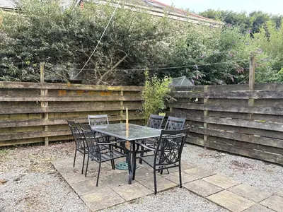 a black table and chairs in a backyard at La Mouette in Mevagissey