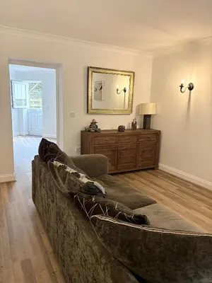 a living room with a couch and a mirror at La Mouette in Mevagissey