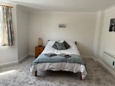 a bedroom with a bed and a window at La Mouette in Mevagissey