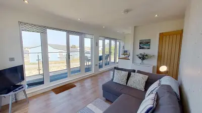 a living room with a couch and a television at D08 Dawn O Day, Riviere Towans in Hayle